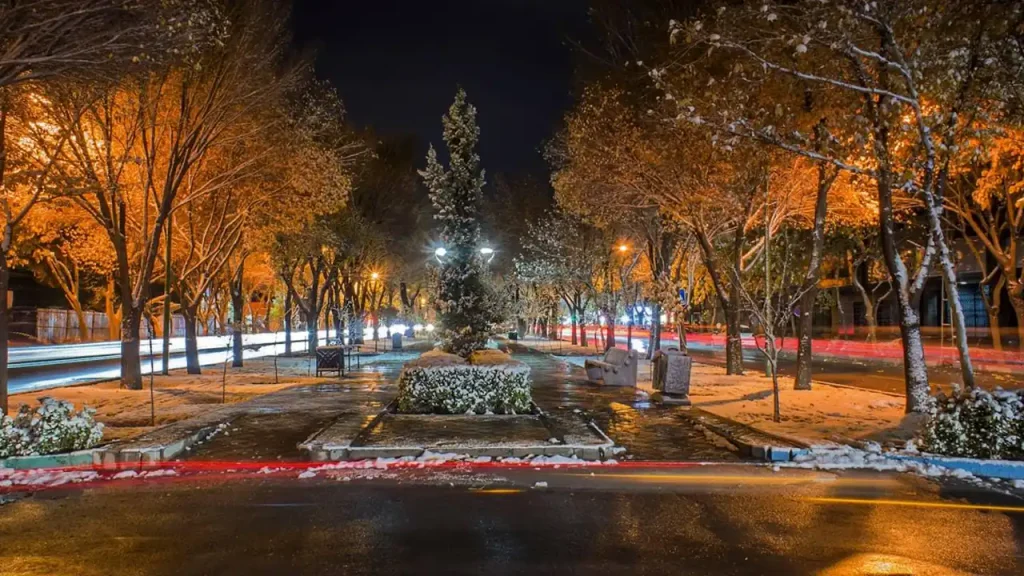 نمای شبانه خیابان چهارباغ عباسی اصفهان با مسیر سنگفرش، درختان و چراغهای روشن